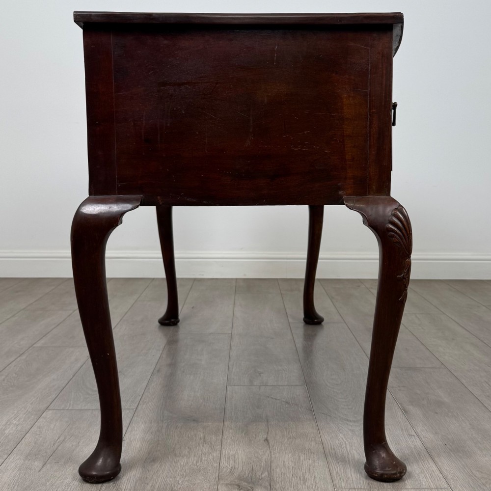 An Edwardian mahogany writing table with cabriole legs, carved knee detailing, three drawers with ornate brass handles, and a central arched kneehole. View VII