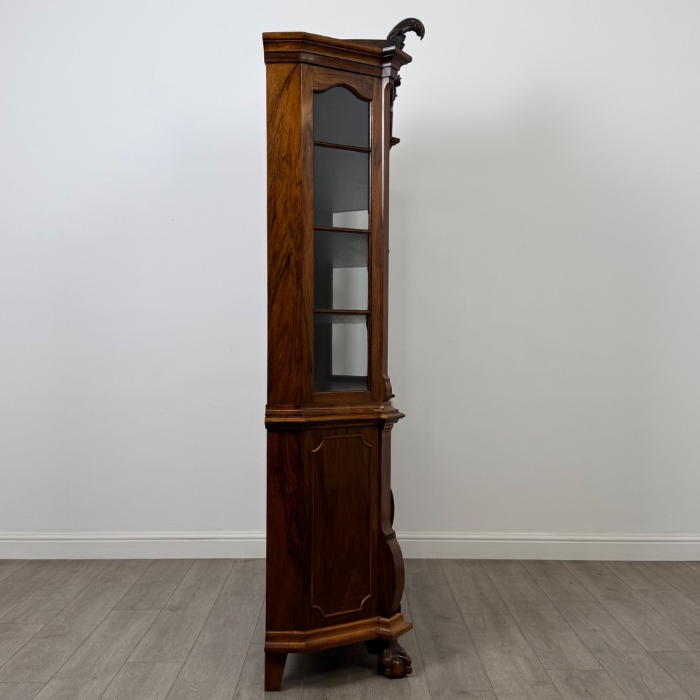 A Dutch walnut display cabinet featuring a carved bonnet-top pediment, multi-pane glazed doors, and a lower chest of drawers on carved claw-and-ball feet. View VIII