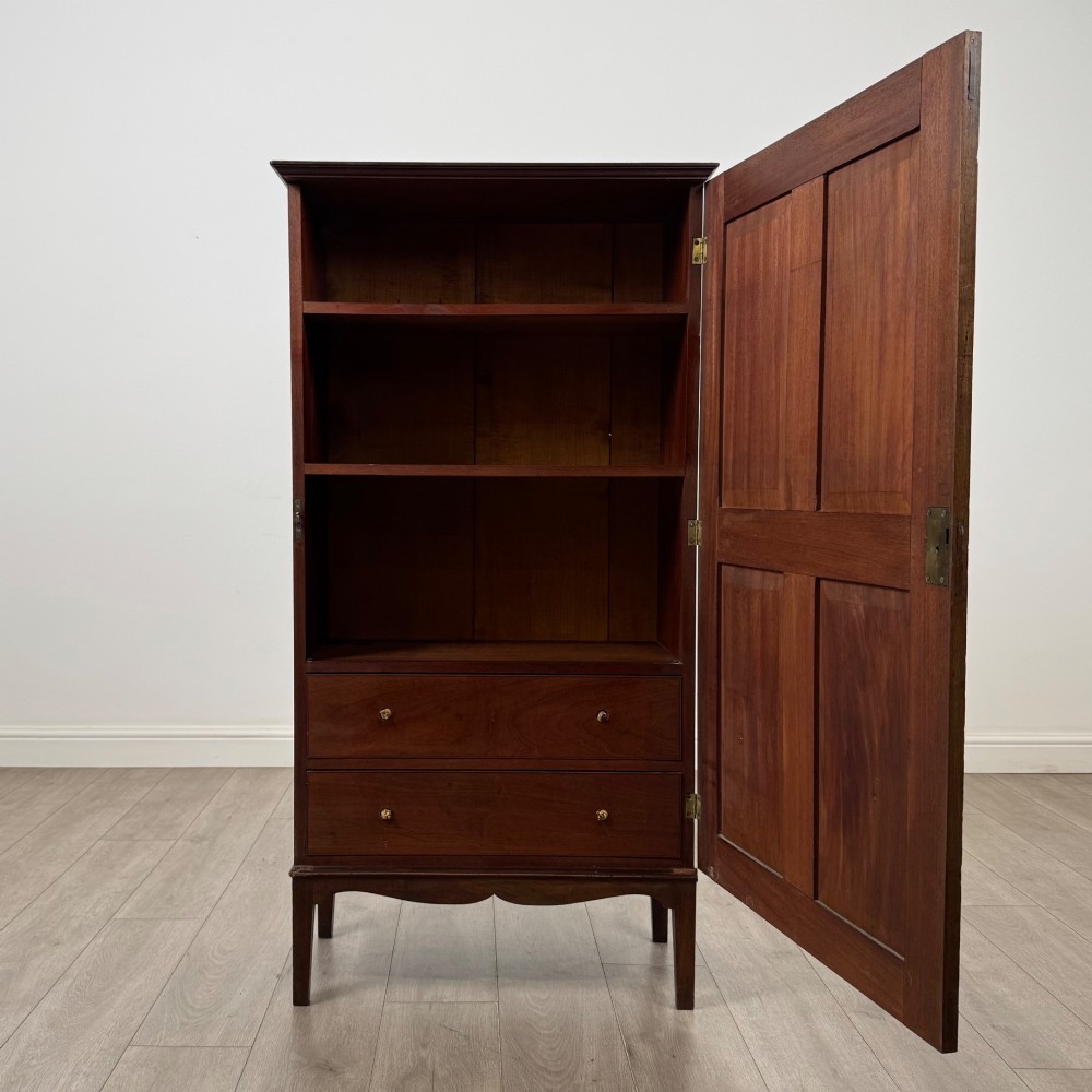 An 18th-century Georgian dark mahogany standing cabinet featuring two tall recessed field-panel doors, a subtle curved apron, and square tapered legs. View II