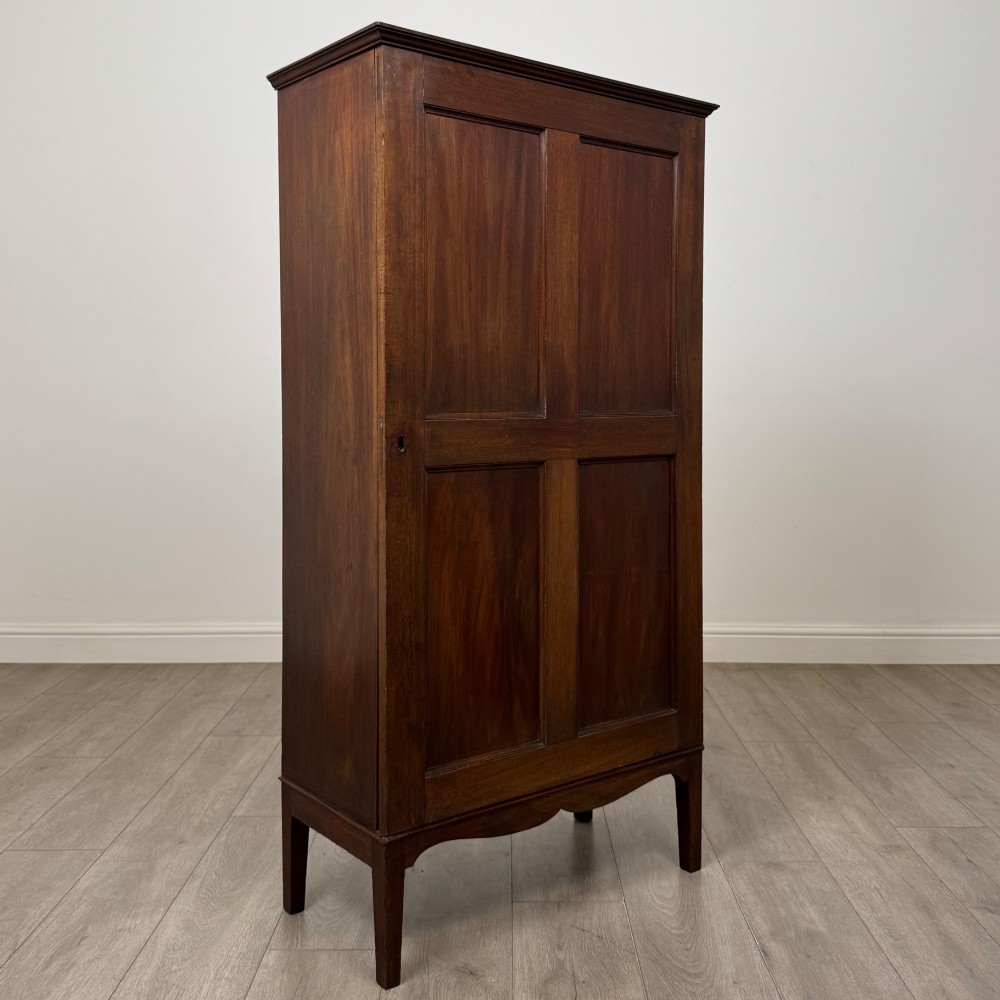 An 18th-century Georgian dark mahogany standing cabinet featuring two tall recessed field-panel doors, a subtle curved apron, and square tapered legs. View IX