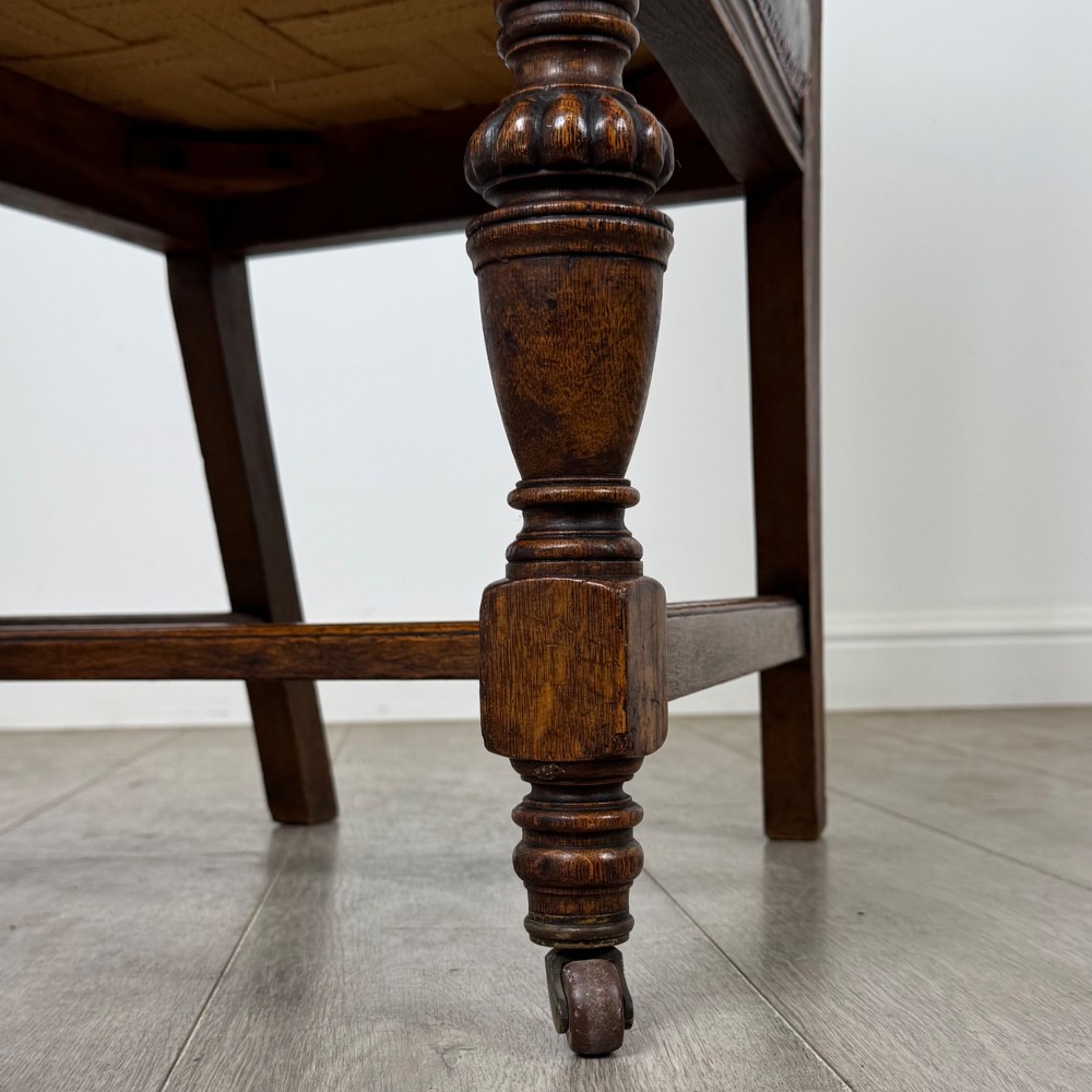 A set of four 19th-century Victorian dark oak dining chairs featuring carved crest rails, turned legs, and light blue patterned fabric upholstery on the seats and backrests. View VI