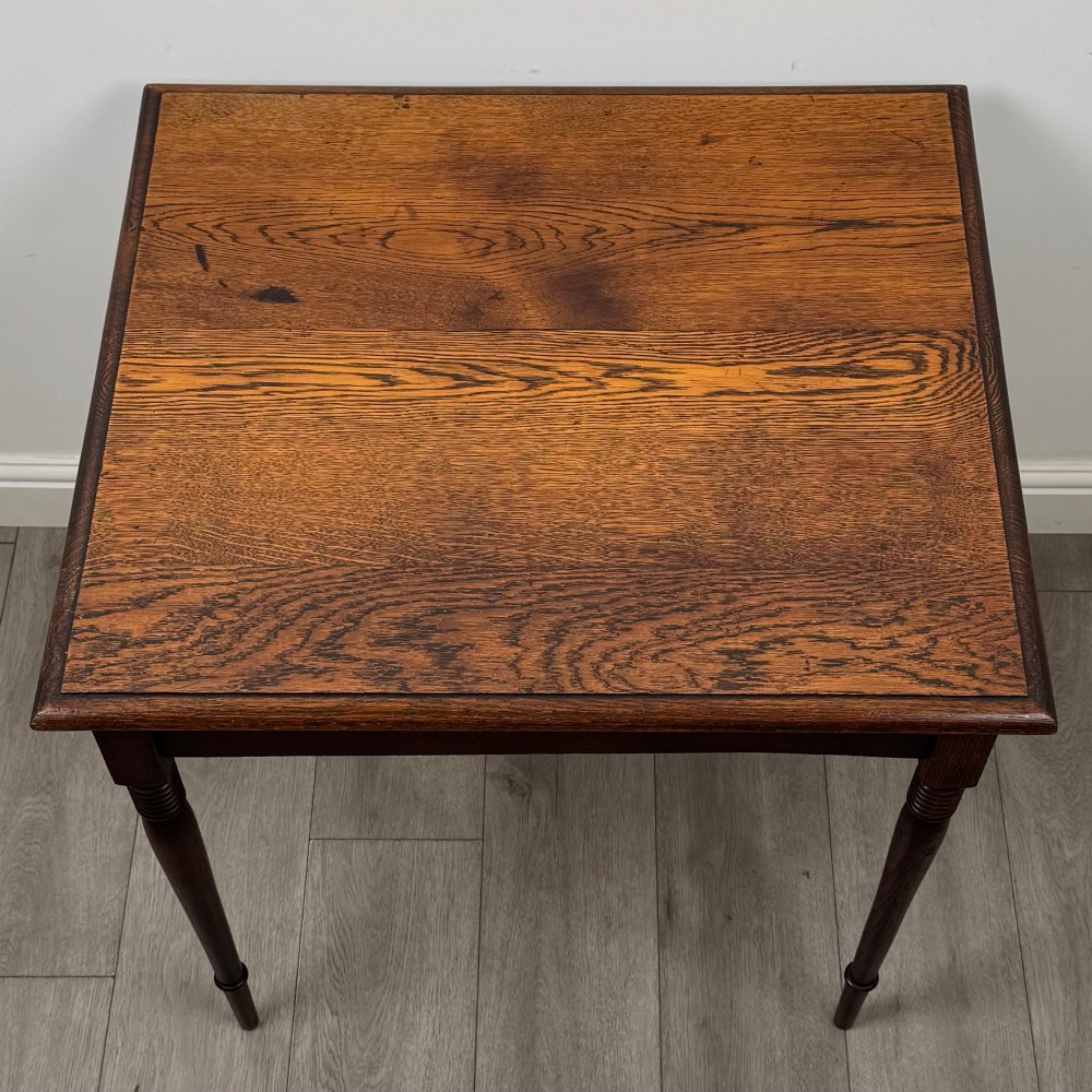 An antique Edwardian dark oak side table featuring slender turned legs with ring details and a smooth square top surface. View IX