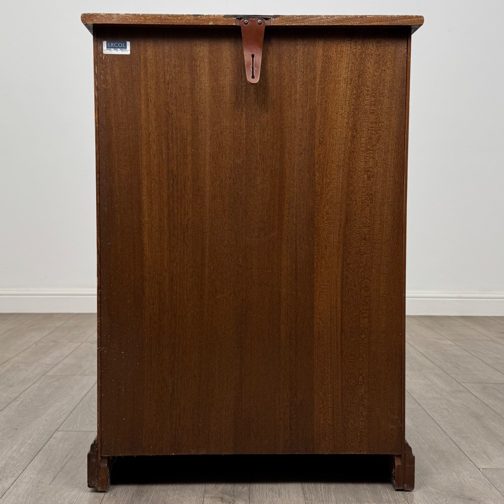 A small vintage dark oak bookcase featuring three open shelves, decorative carved detailing along the frieze and side uprights, and a solid plinth base. View VI