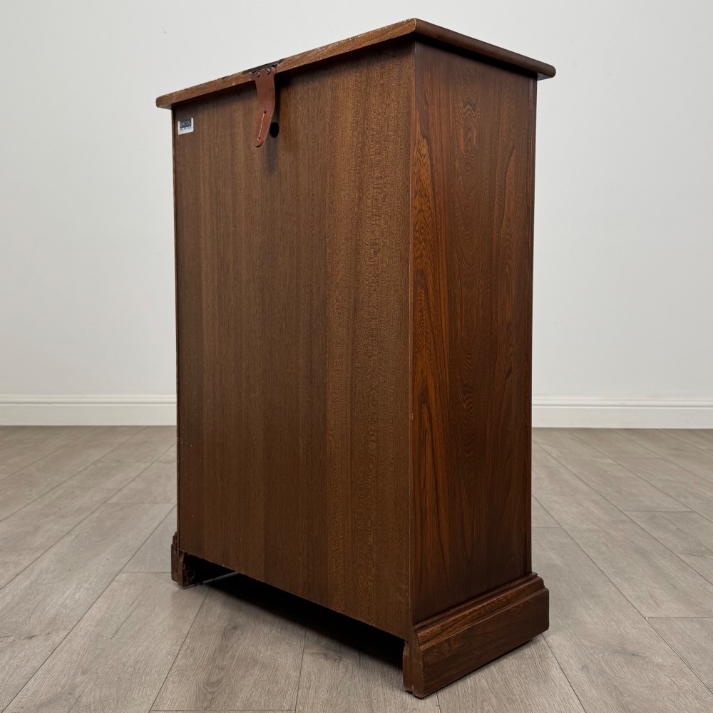 A small vintage dark oak bookcase featuring three open shelves, decorative carved detailing along the frieze and side uprights, and a solid plinth base. View VII