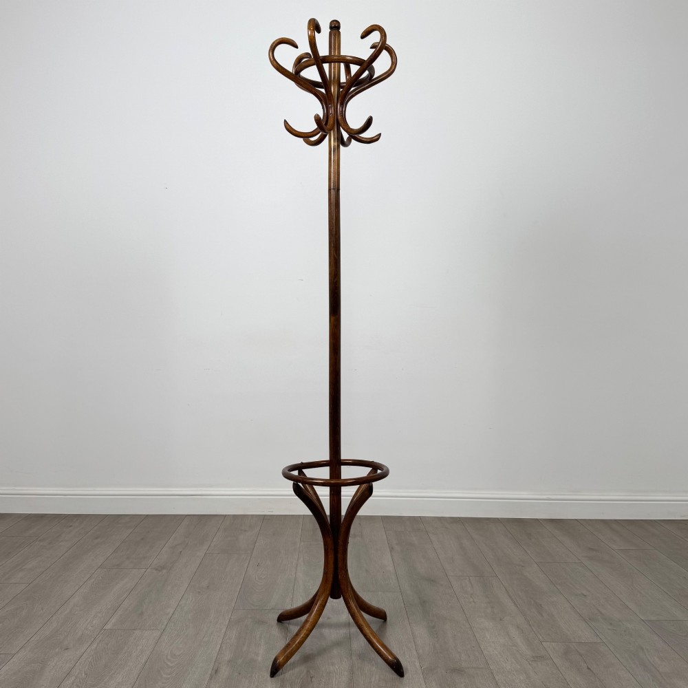 A freestanding bentwood beech coat stand featuring curved upper hooks, a central umbrella ring, and splayed feet.