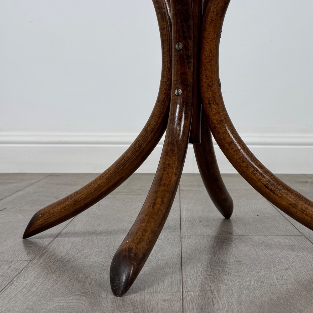 A freestanding bentwood beech coat stand featuring curved upper hooks, a central umbrella ring, and splayed feet. View VI