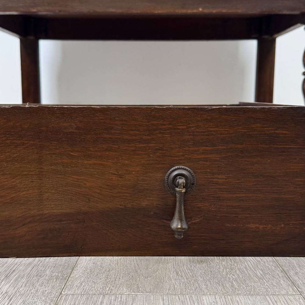 An Edwardian dark oak writing bureau featuring a sloped drop-down lid, two lower drawers with teardrop handles, and turned legs connected by stretchers. View XIII