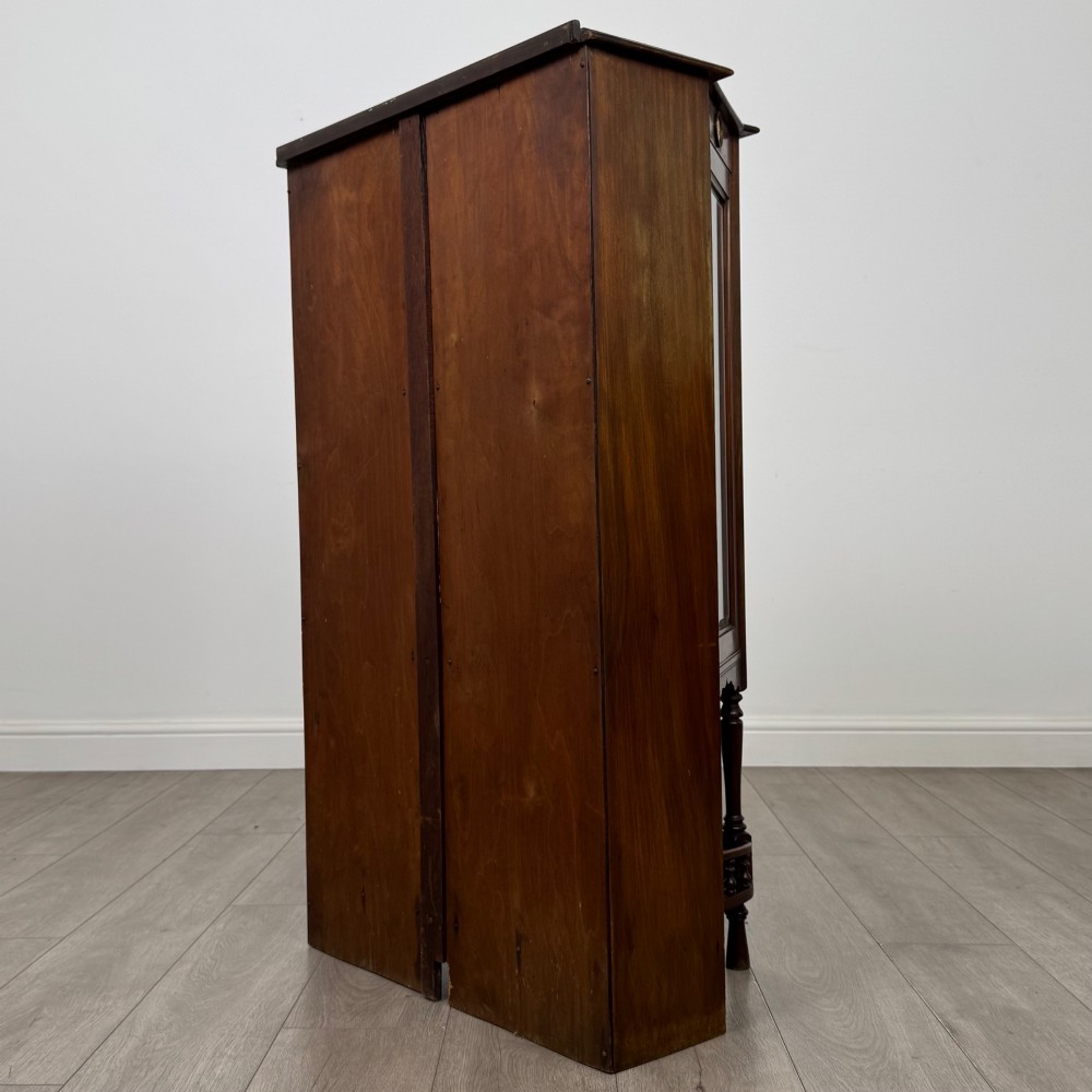 An antique walnut display cabinet featuring glazed door and side panels, decorative inlay along the frieze, and an open lower shelf resting on turned front legs. View VII