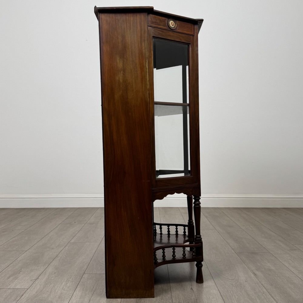 An antique walnut display cabinet featuring glazed door and side panels, decorative inlay along the frieze, and an open lower shelf resting on turned front legs. View VIII