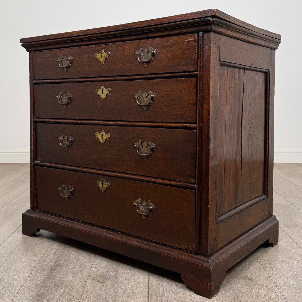 An 18th-century dark oak Georgian chest of drawers featuring four graduated drawers with brass handles and keyhole escutcheons. View II