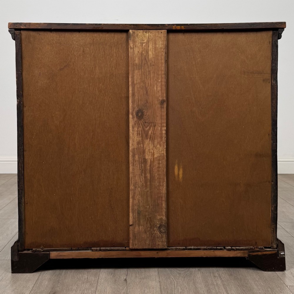An 18th-century dark oak Georgian chest of drawers featuring four graduated drawers with brass handles and keyhole escutcheons. View V