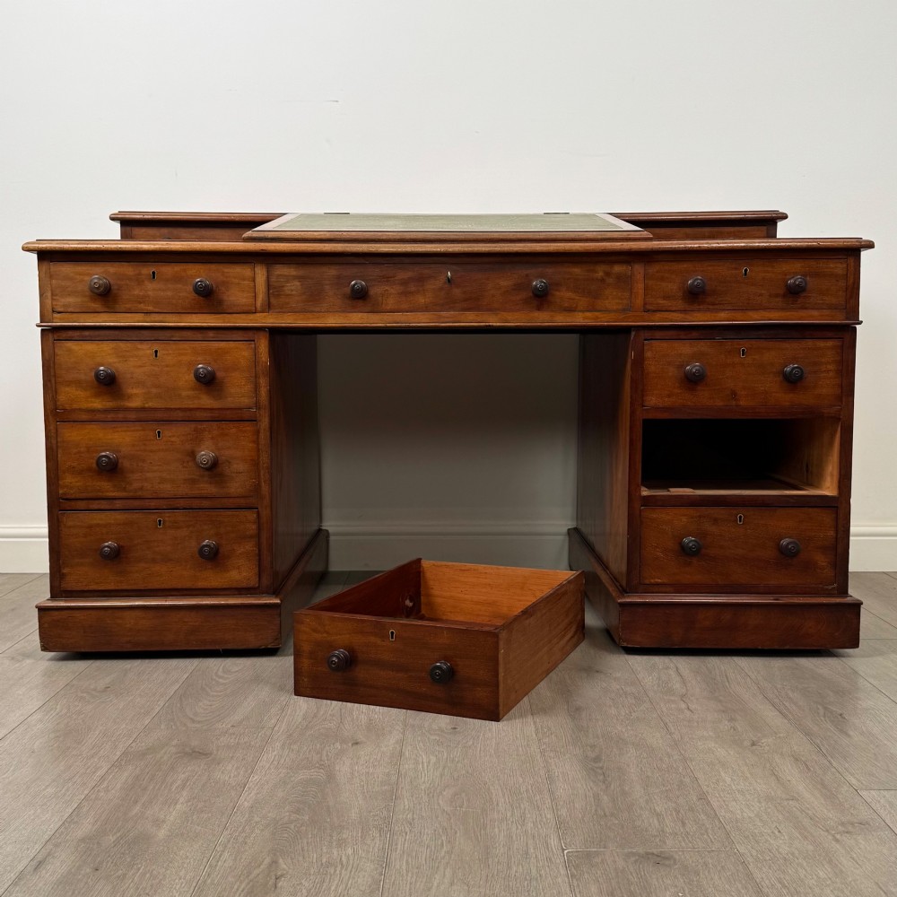 A 19th-century Victorian mahogany Dickens desk featuring a sloped green leather writing top, a raised rear superstructure, and twin pedestals fitted with turned knobs. View XI