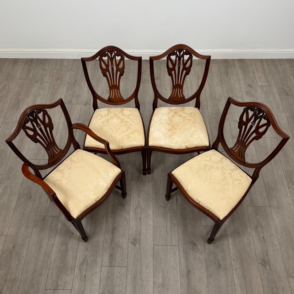 A set of eight mahogany shield back dining chairs featuring intricate pierced back splats and light cream upholstered seats. View VII