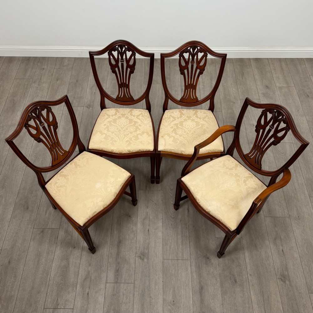 A set of eight mahogany shield back dining chairs featuring intricate pierced back splats and light cream upholstered seats. View VIII