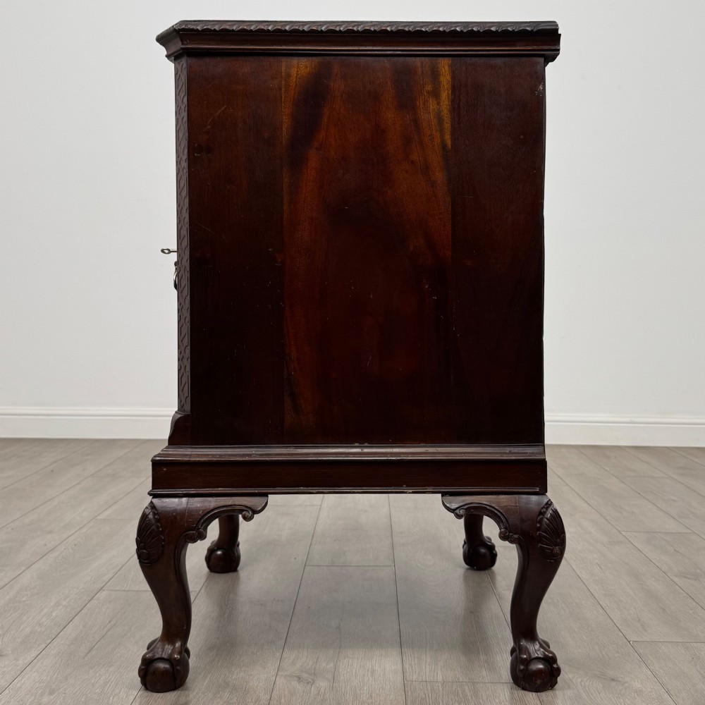 A dark mahogany Chippendale style cupboard featuring a single door with an oval flame mahogany panel, carved borders, and cabriole legs with ball-and-claw feet. View IV
