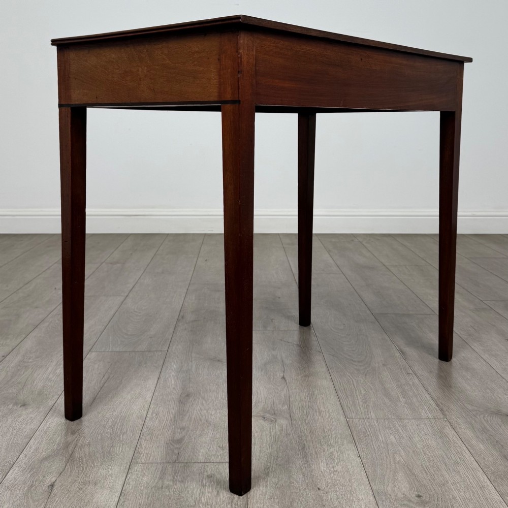 An 18th-century Georgian mahogany writing table featuring a single drawer with brass handles and four square tapered legs. View IV