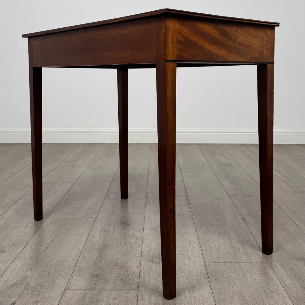 An 18th-century Georgian mahogany writing table featuring a single drawer with brass handles and four square tapered legs. View VI