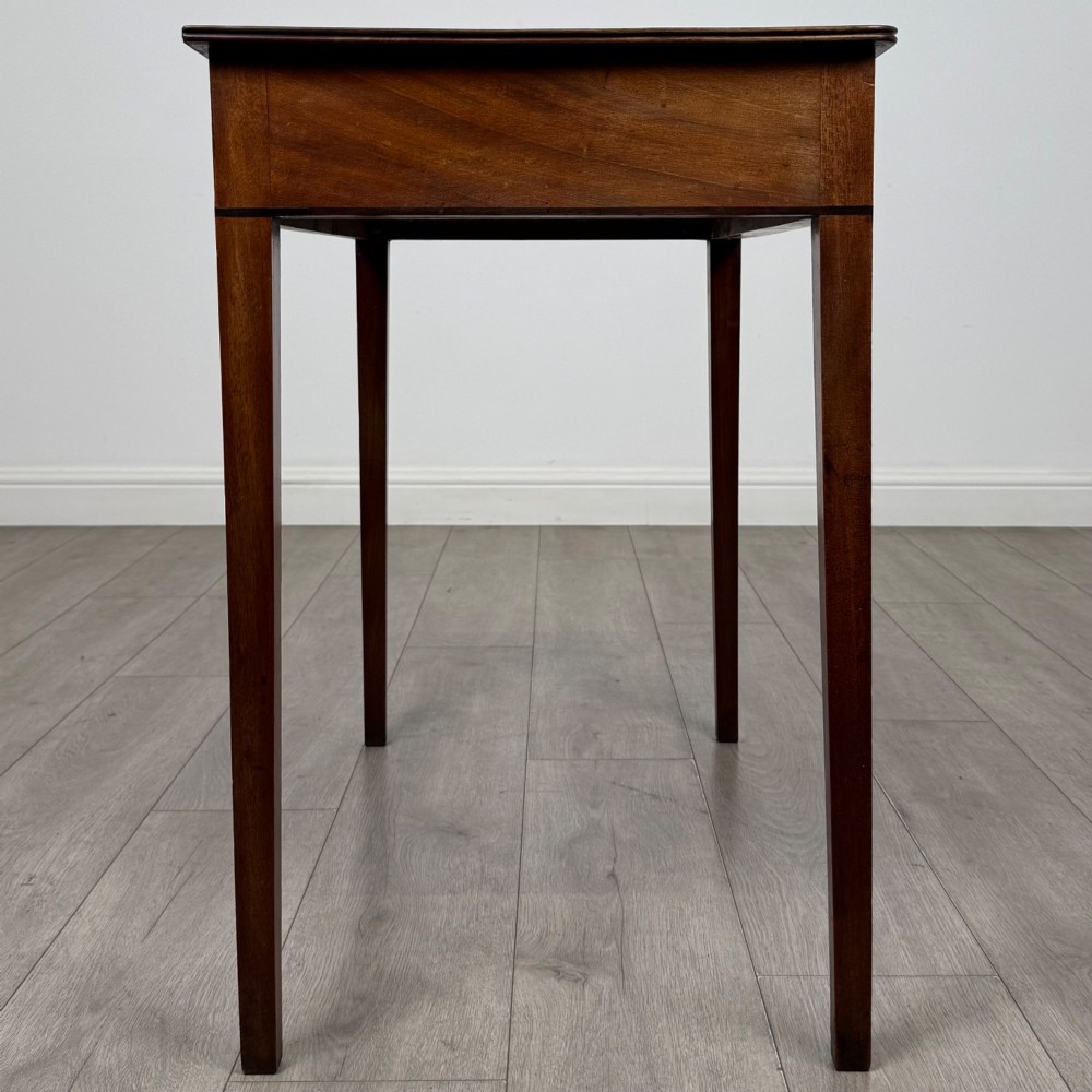An 18th-century Georgian mahogany writing table featuring a single drawer with brass handles and four square tapered legs. View VII