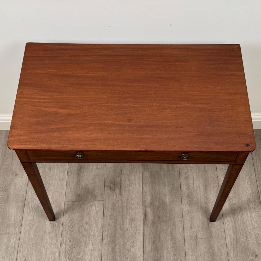 An 18th-century Georgian mahogany writing table featuring a single drawer with brass handles and four square tapered legs. View IX