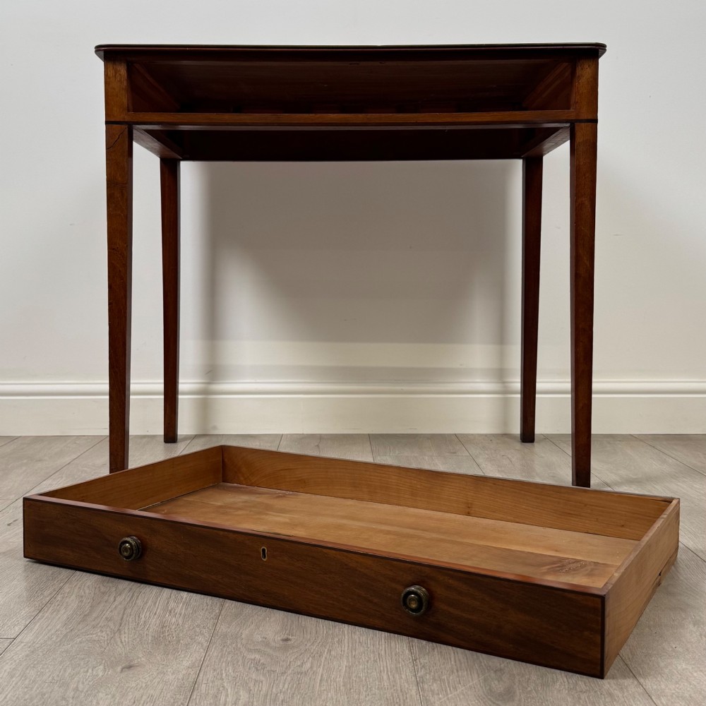 An 18th-century Georgian mahogany writing table featuring a single drawer with brass handles and four square tapered legs. View X