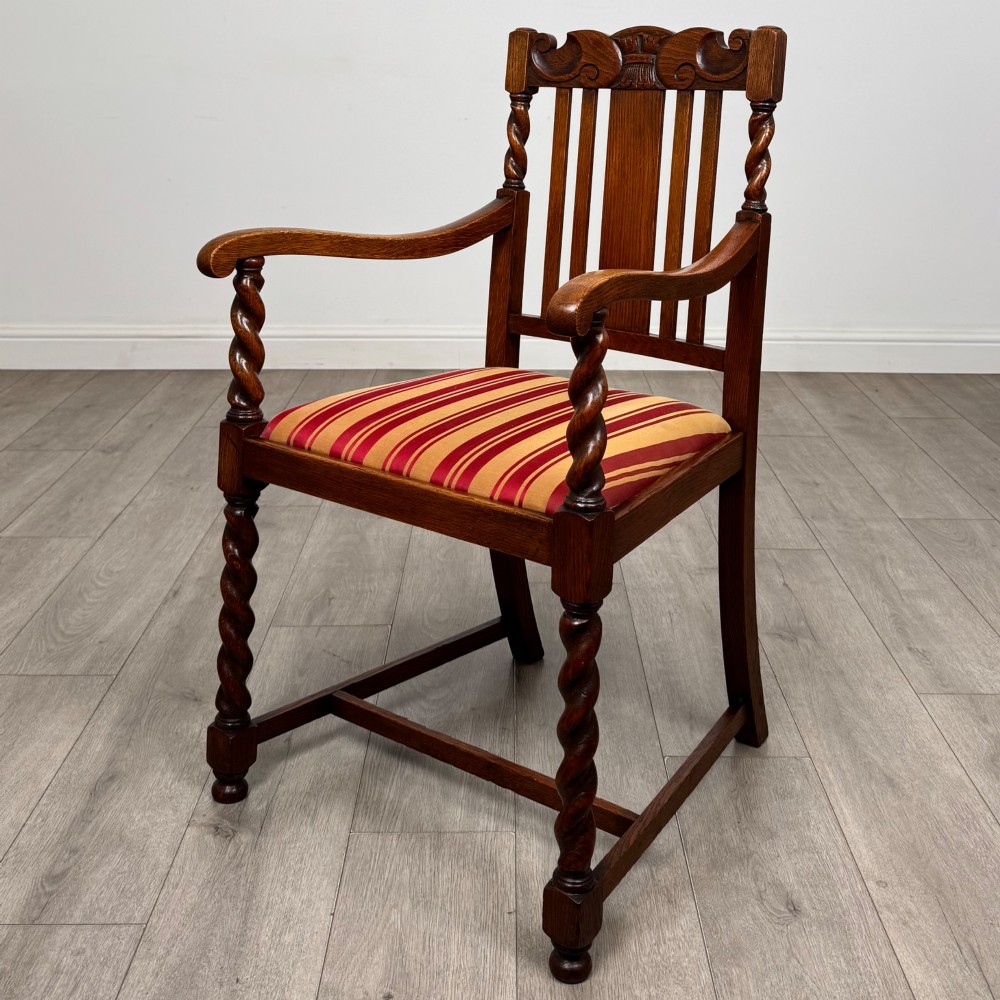 A set of ten early twentieth-century oak dining chairs featuring barley twist turned legs and supports with red and yellow striped upholstered seats. View II