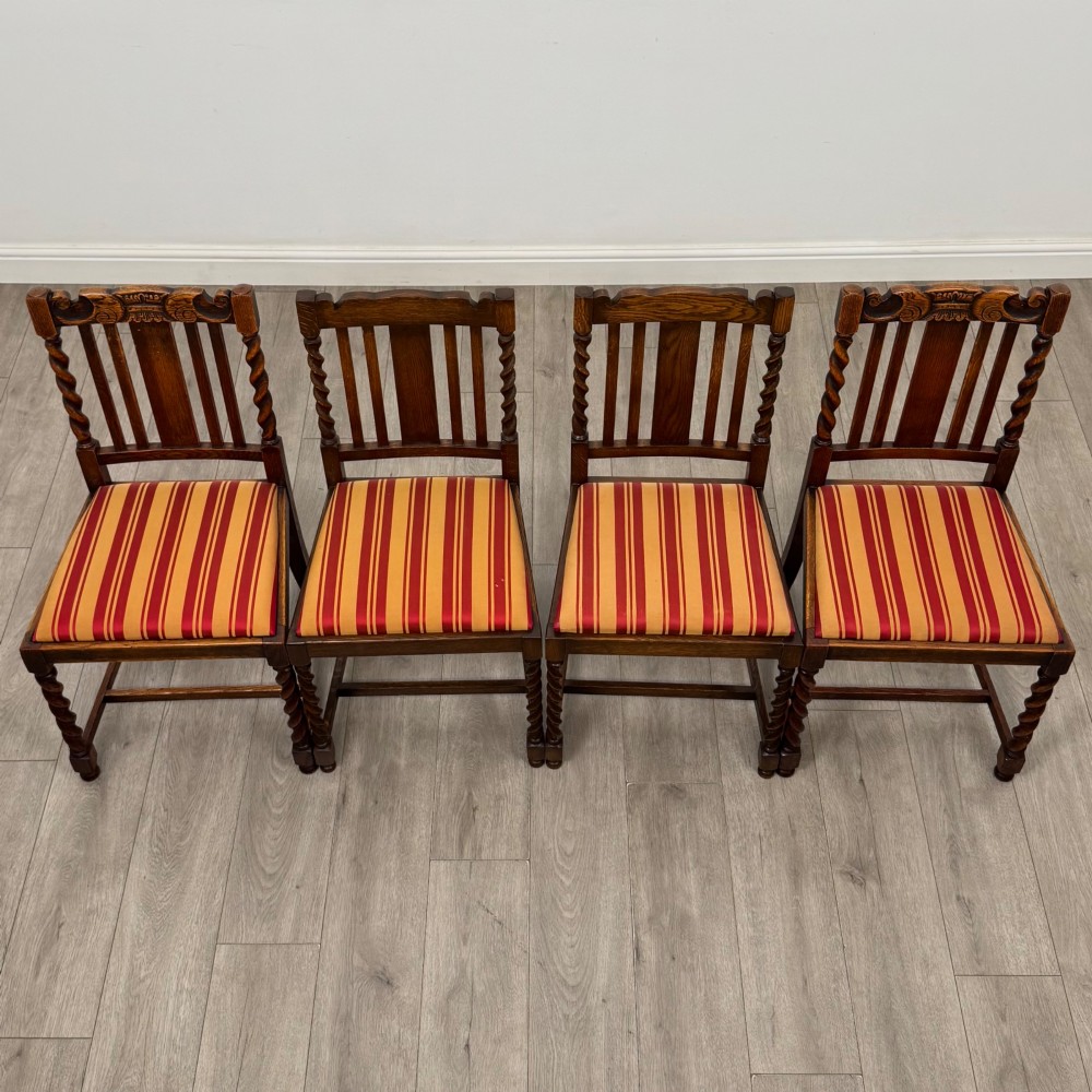 A set of ten early twentieth-century oak dining chairs featuring barley twist turned legs and supports with red and yellow striped upholstered seats. View VIII