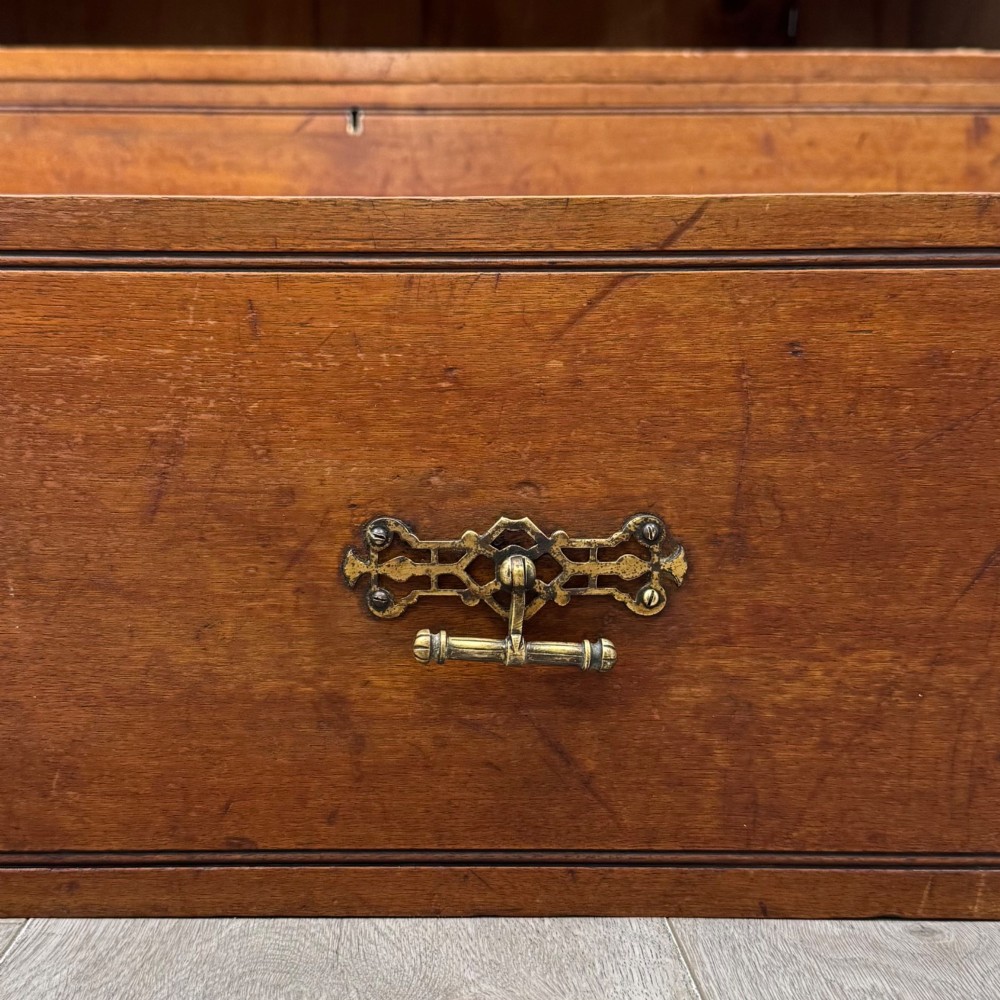 An antique walnut chest of drawers featuring decorative brass handles, reeded top drawer fronts, and a solid plinth base. View XI