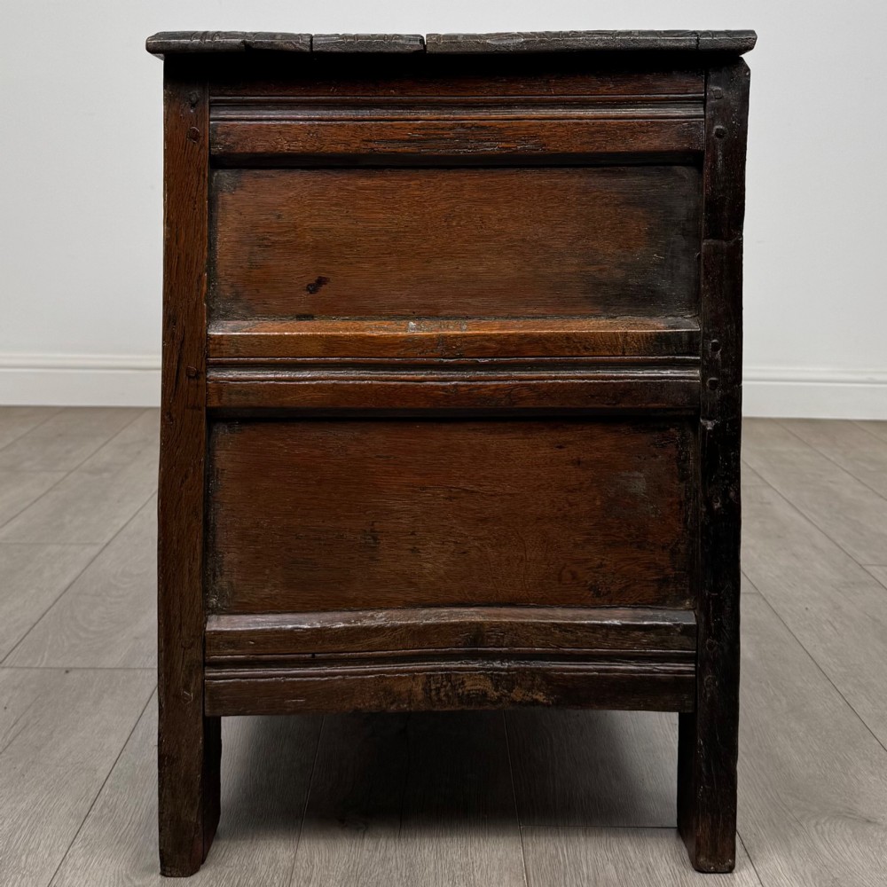 A low dark oak Victorian cupboard featuring two doors with relief carvings of birds and flowers, flanked by leafy carved uprights and a carved frieze. View IV