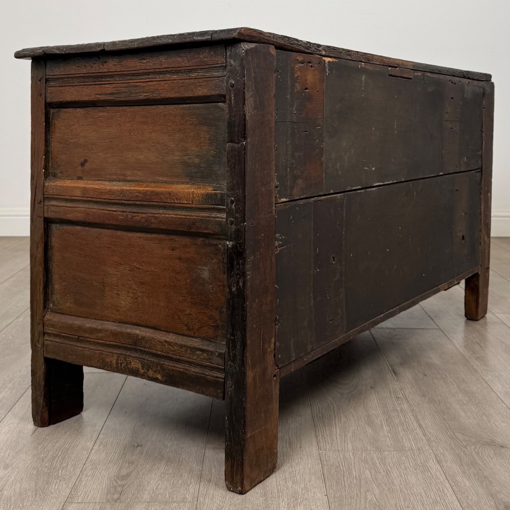 A low dark oak Victorian cupboard featuring two doors with relief carvings of birds and flowers, flanked by leafy carved uprights and a carved frieze. View V