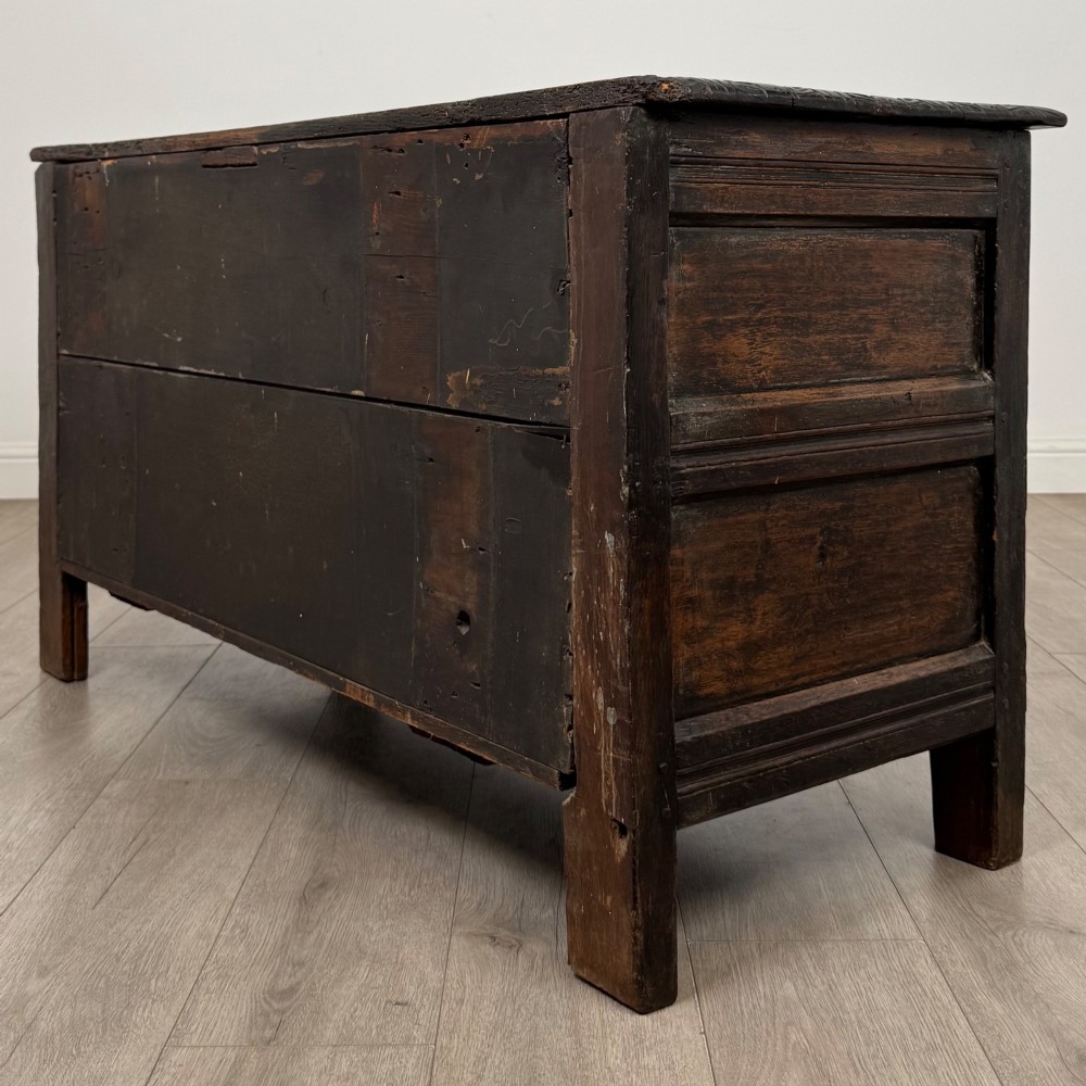 A low dark oak Victorian cupboard featuring two doors with relief carvings of birds and flowers, flanked by leafy carved uprights and a carved frieze. View VII