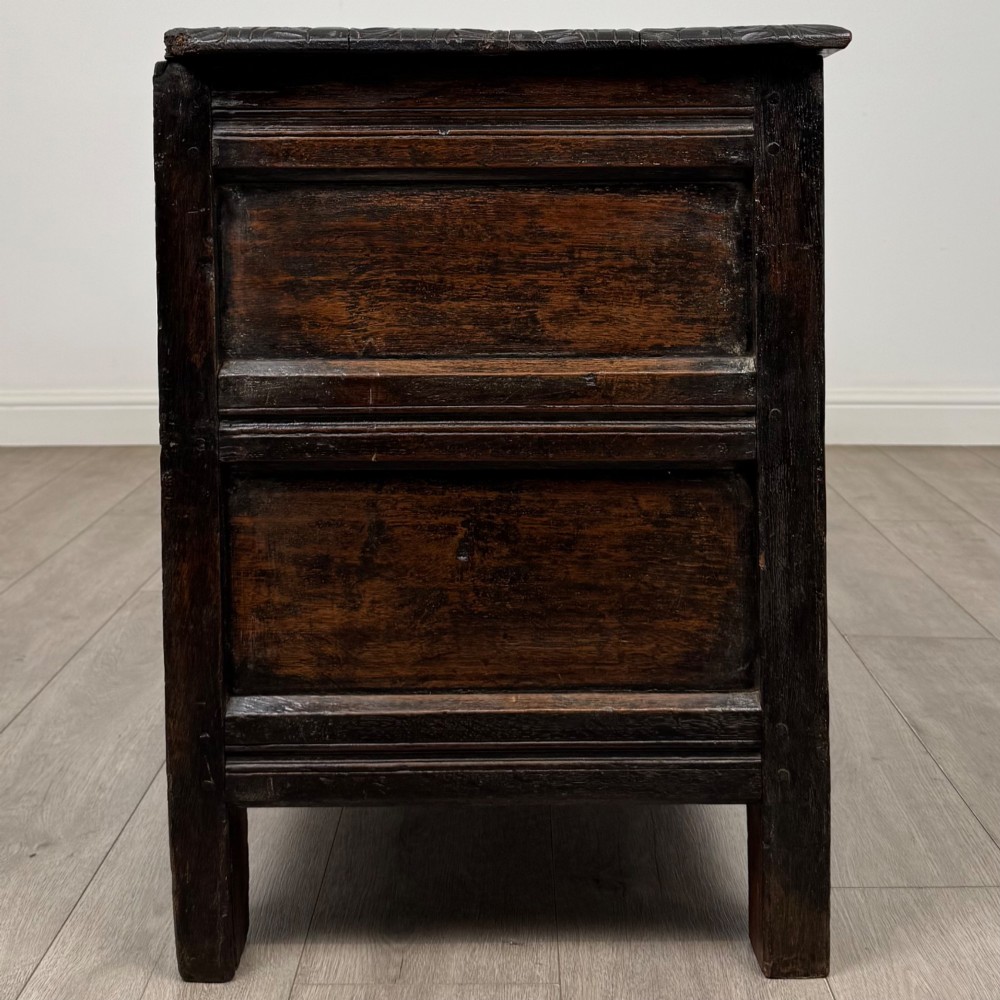 A low dark oak Victorian cupboard featuring two doors with relief carvings of birds and flowers, flanked by leafy carved uprights and a carved frieze. View VIII