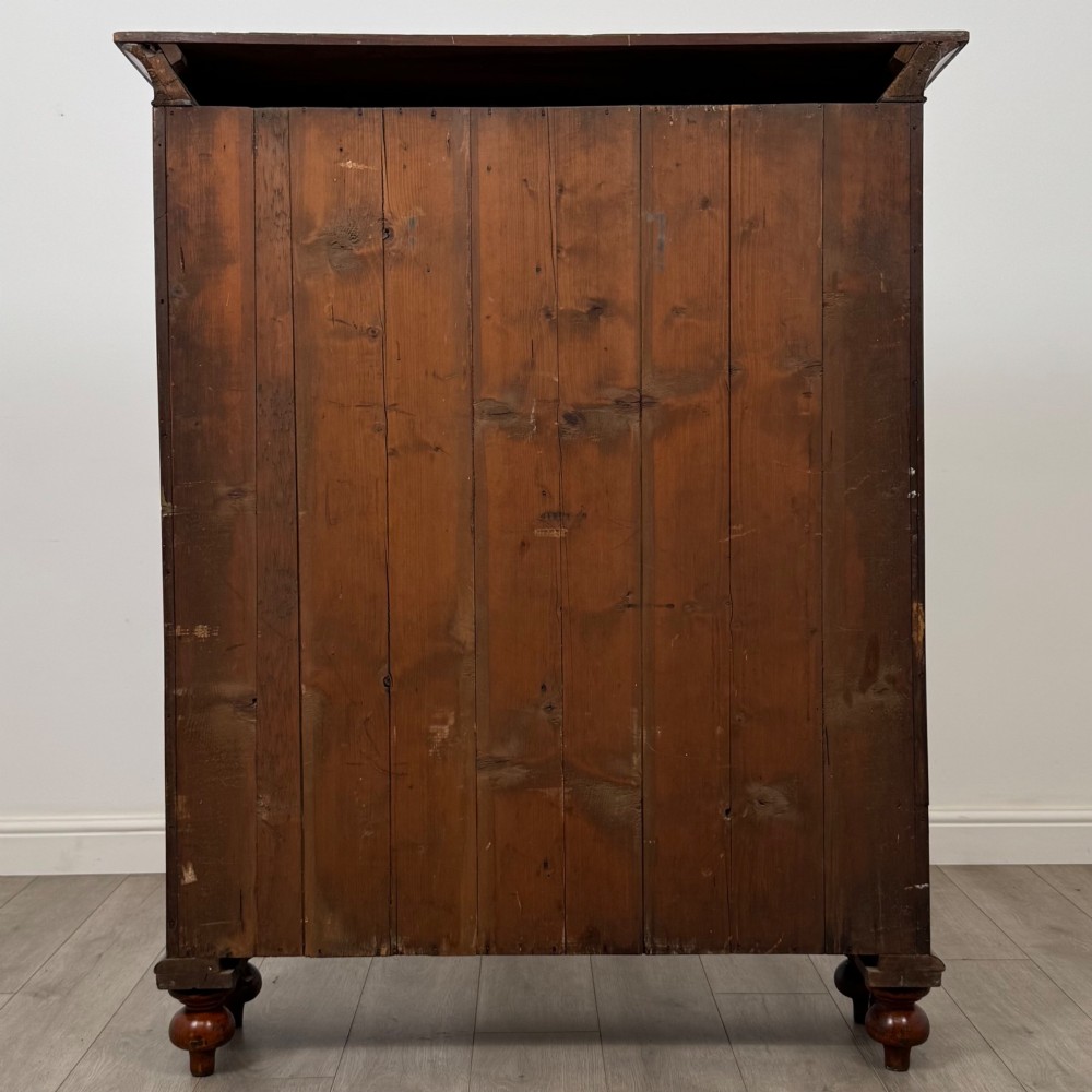 An antique Victorian mahogany storage cabinet featuring two panelled doors, turned bun feet, and a classic moulded top cornicing. View VI