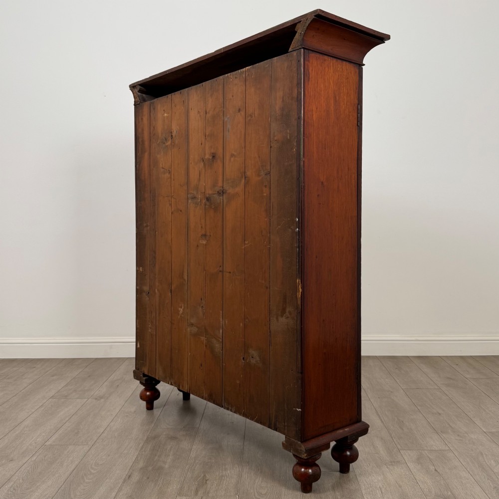 An antique Victorian mahogany storage cabinet featuring two panelled doors, turned bun feet, and a classic moulded top cornicing. View VII
