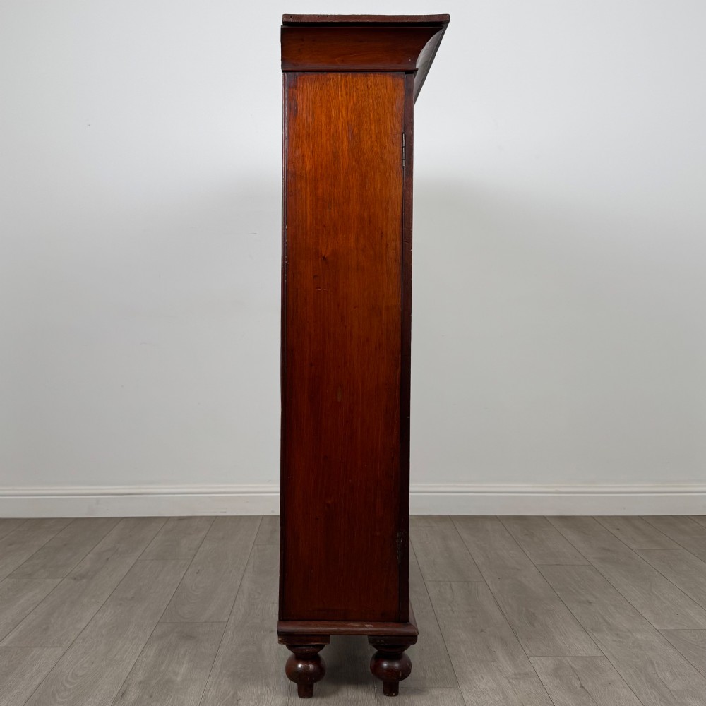 An antique Victorian mahogany storage cabinet featuring two panelled doors, turned bun feet, and a classic moulded top cornicing. View VIII