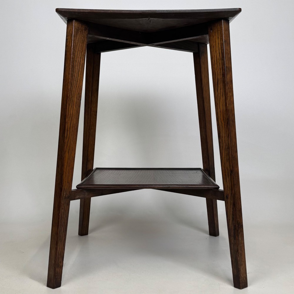 An Edwardian dark oak side table featuring a square top, cross-stretchers, tapered legs, and a lower square shelf. View III