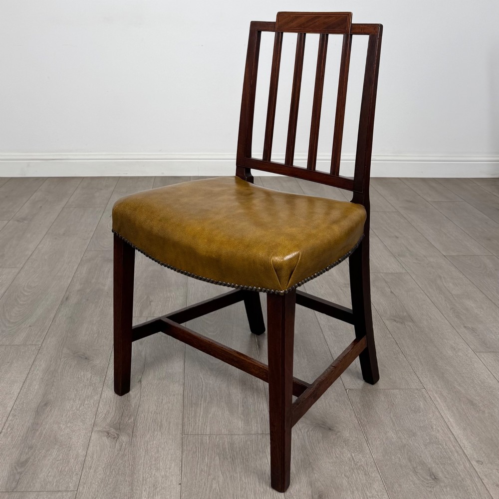 A set of six antique mahogany dining chairs featuring vertical slat backs, square legs, and olive green leather seats finished with brass studs. View II
