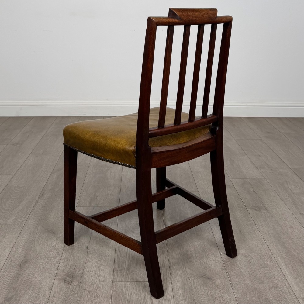 A set of six antique mahogany dining chairs featuring vertical slat backs, square legs, and olive green leather seats finished with brass studs. View III