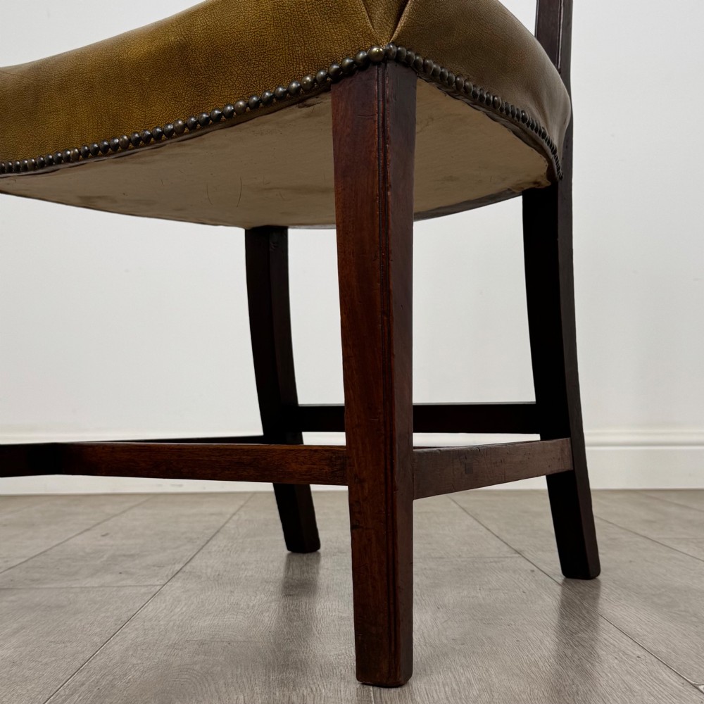 A set of six antique mahogany dining chairs featuring vertical slat backs, square legs, and olive green leather seats finished with brass studs. View V