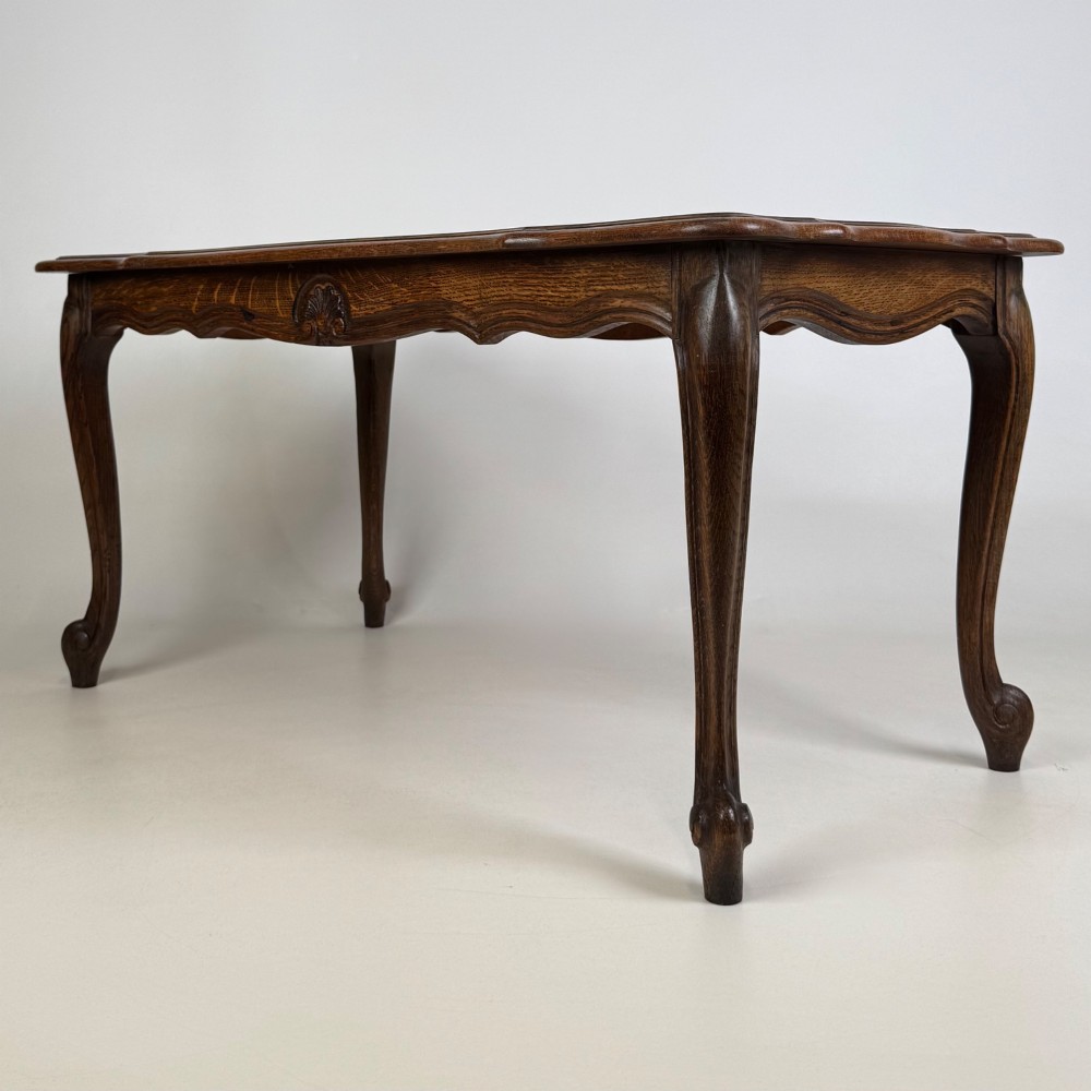 A 20th-century dark oak coffee table featuring cabriole legs, a serpentine apron, and a central carved shell motif. View II
