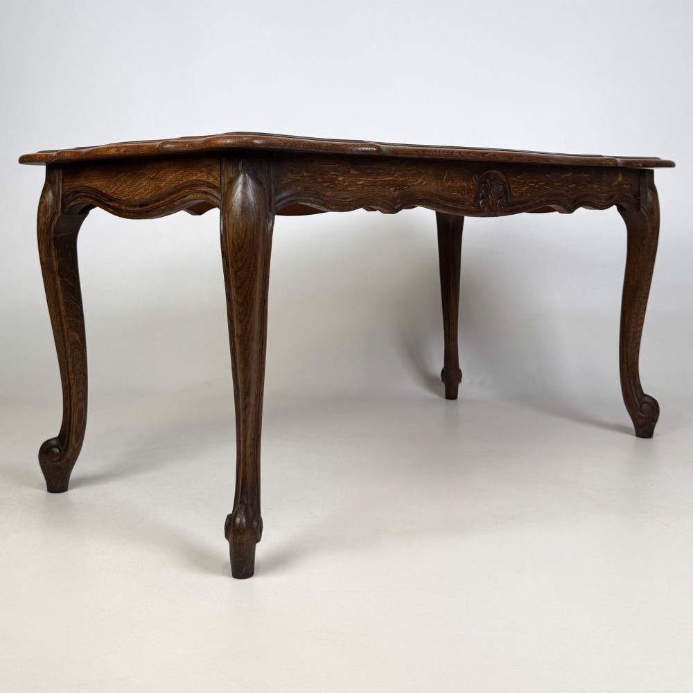 A 20th-century dark oak coffee table featuring cabriole legs, a serpentine apron, and a central carved shell motif. View IV