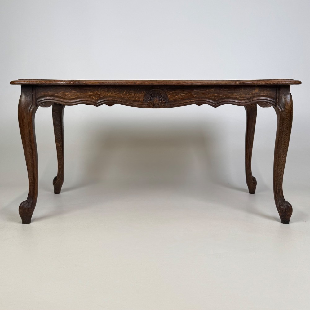 A 20th-century dark oak coffee table featuring cabriole legs, a serpentine apron, and a central carved shell motif. View V