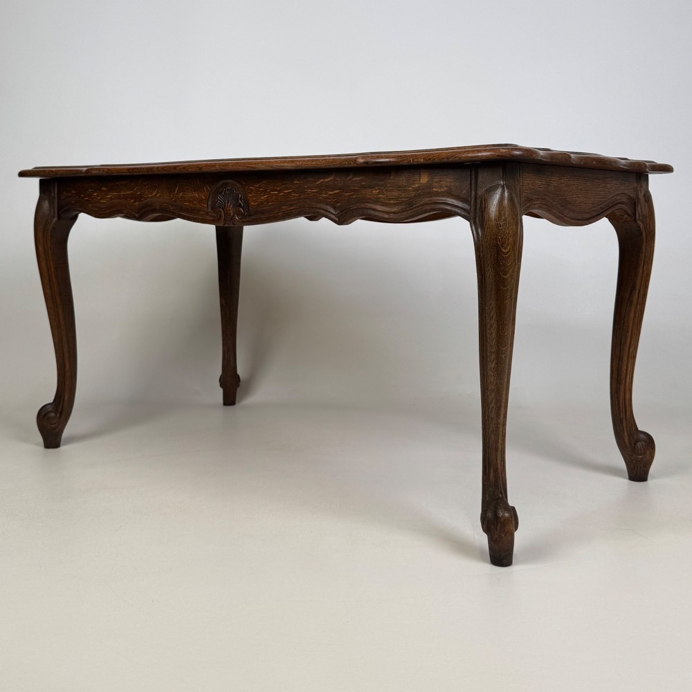 A 20th-century dark oak coffee table featuring cabriole legs, a serpentine apron, and a central carved shell motif. View VI