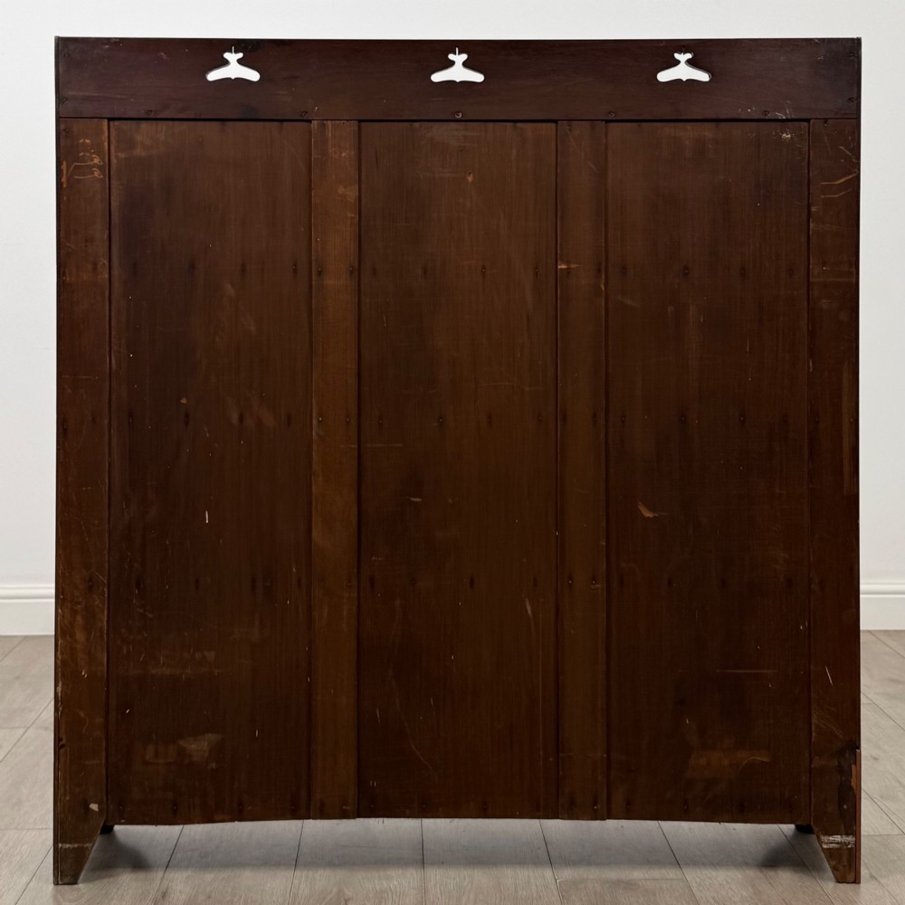An early 20th-century Arts and Crafts open walnut bookcase featuring four shelves and decorative pierced cut-outs on the top gallery and plinth base. View VI