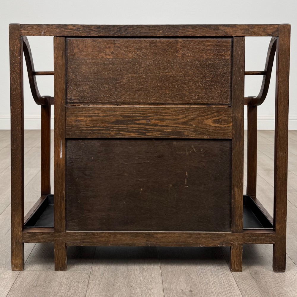 An antique Edwardian golden oak hall seat featuring a central panelled backrest and integrated side umbrella stands with metal drip trays. View V