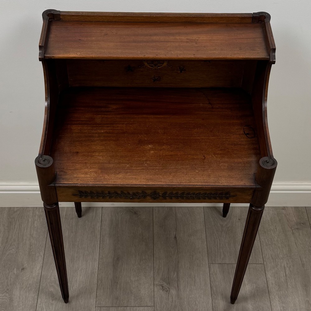 A French mahogany side table featuring slim tapered fluted legs, a carved laurel motif apron, and a gallery back adorned with brass stars. View IX