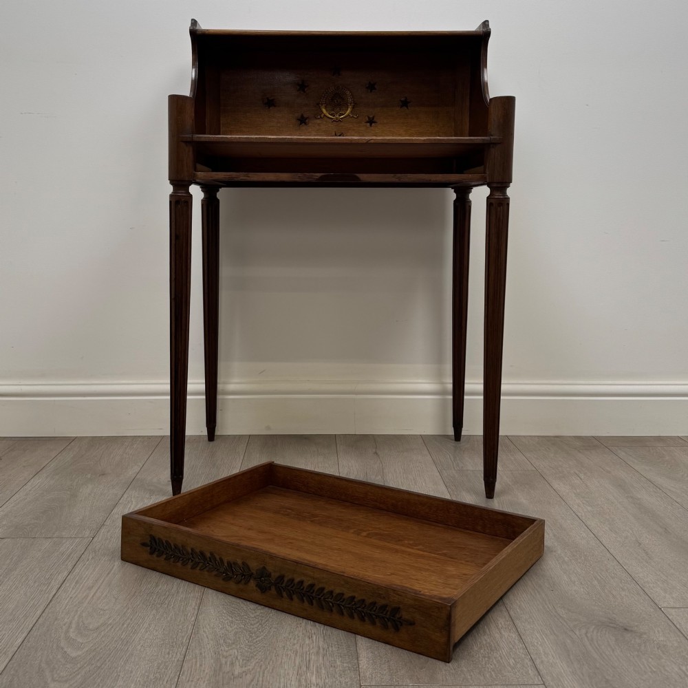 A French mahogany side table featuring slim tapered fluted legs, a carved laurel motif apron, and a gallery back adorned with brass stars. View X