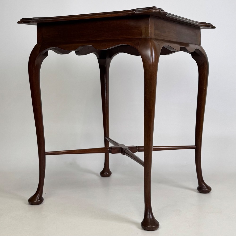 An Edwardian mahogany side table featuring elegant cabriole legs, a shaped apron, and a central X-frame stretcher. View II