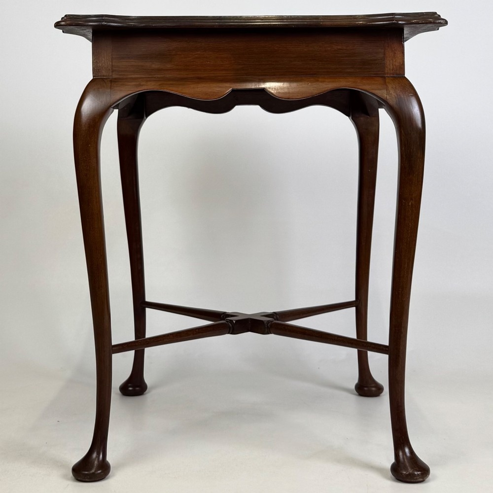 An Edwardian mahogany side table featuring elegant cabriole legs, a shaped apron, and a central X-frame stretcher. View III