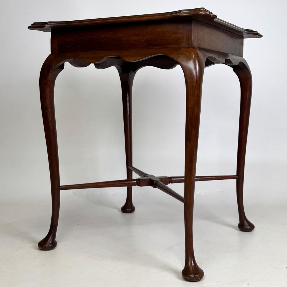 An Edwardian mahogany side table featuring elegant cabriole legs, a shaped apron, and a central X-frame stretcher. View VI