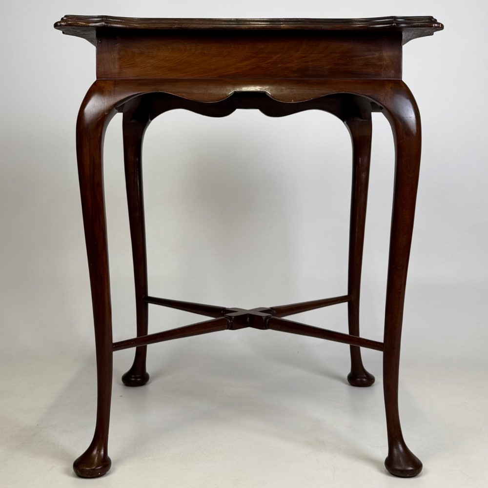 An Edwardian mahogany side table featuring elegant cabriole legs, a shaped apron, and a central X-frame stretcher. View VII